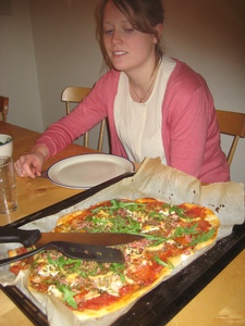 Serverad pizza med Johanna i bakgrund.